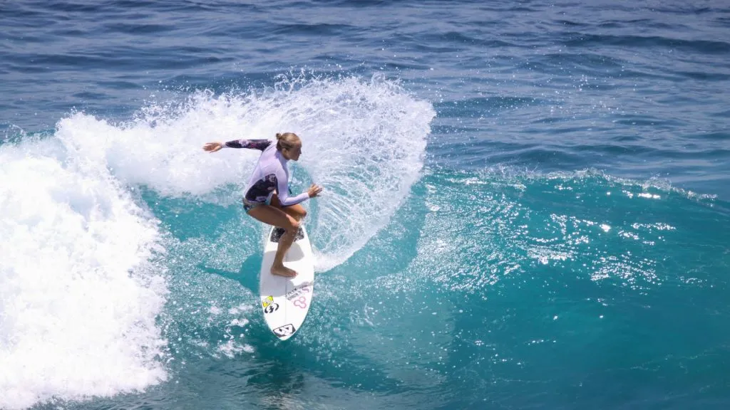 Surfer riding a wave at Sanur Reef during sunrise in Bali