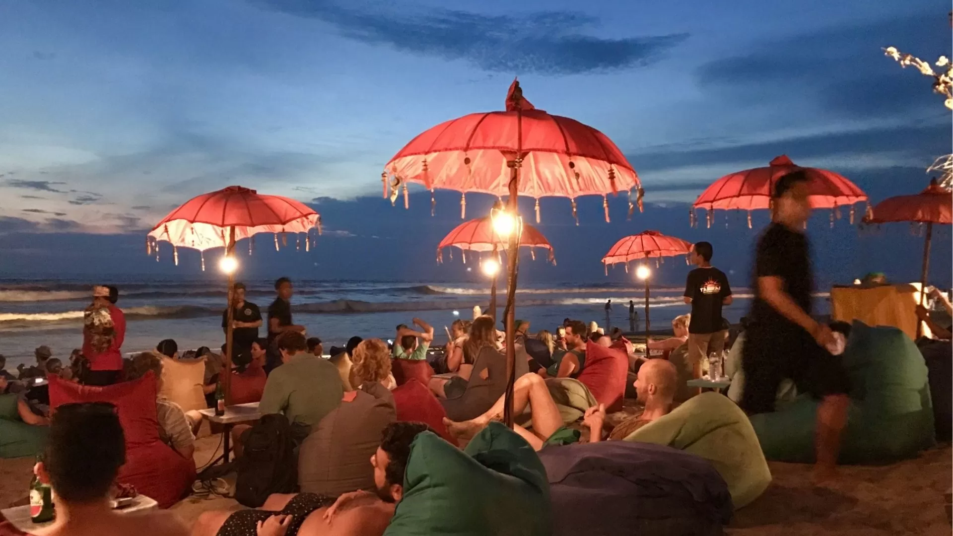 Colorful beach umbrellas on Seminyak Beach at sunset Bali