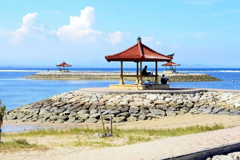 Family cycling along the sunrise beachfront path in Sanur, Bali